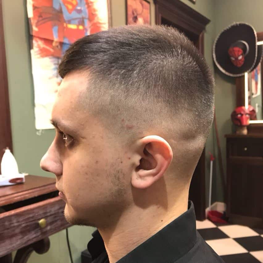 A crew cut style with hair on top swept to one side and paired with faded sides and back